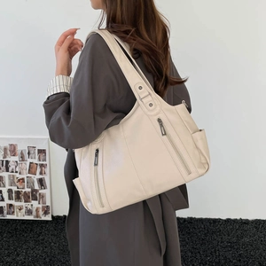 Off-white large capacity tote bag with dual zipper details shown on model in studio