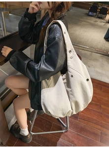 Detail of off-white oversized nylon tote bag with metal eyelet accents and spacious design