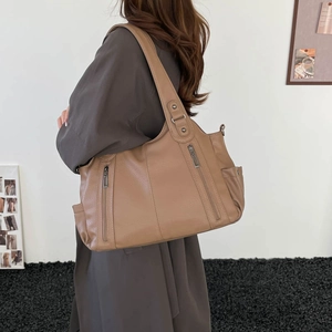 Detail of dark khaki tote bag showing lychee grain texture and side pocket on shoulder bag