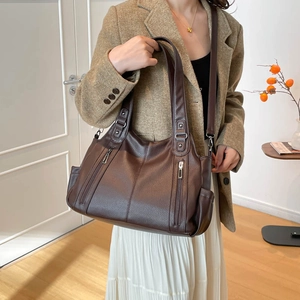Close-up of deep brown litchi pattern leather tote bag with vertical zipper details