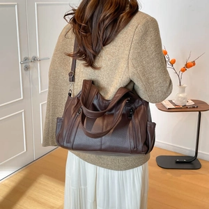 Detail of dark brown tote bag with lychee texture and front double zipper pockets