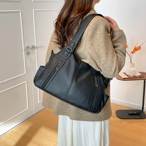 Macro detail of black litchi grain faux leather tote bag with stylish vertical zippers