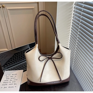 Gedetailleerd beeld van crème-bruine tote bag met leren strik en GONGZHU-reliëflogo