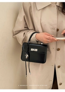 Minimalistische schwarze Handtasche aus mattem Leder mit silbernem Drehverschluss
