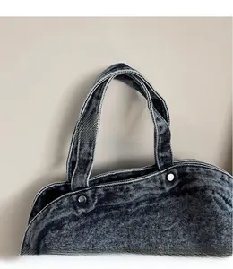 Close-up of denim tote bag handles with durable stitching and silver metal rivets