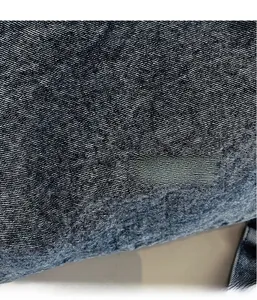 Close-up of premium dark blue washed denim fabric with twill weave texture and high detail