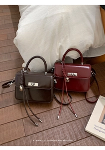 Detail of elegant square handbags with glossy leather finish and heart tassels
