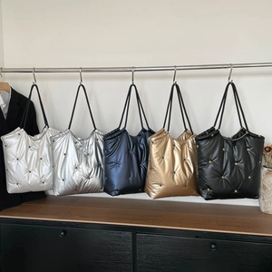 Detailed view of quilted tote bags in five colors with metallic finish and star details