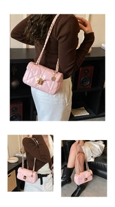 Detail view of pink quilted handbag with gold chain strap and elegant twist lock closure