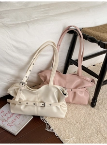 Detail einer minimalistischen Ledertasche mit dekorativer Schnalle in Cremeweiß und Rosa