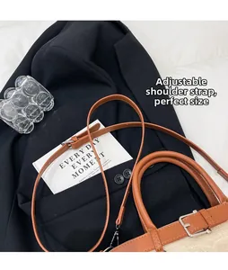 Vue détaillée du sac seau tissé avec bordure en cuir marron et bandoulière réglable