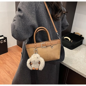 Sac seau tissé marron avec un charm lapin en peluche beige et des anses en cuir