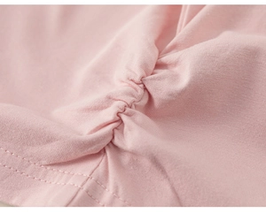 Close-up of pink knitted cotton fabric showing ruched design and double-needle stitching