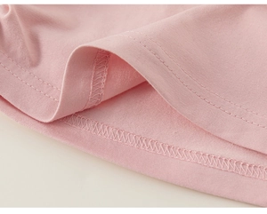 Close-up of double-stitched hem on pink cotton t-shirt showing high-quality sewing craft