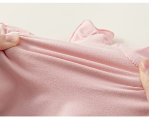 Close-up of pink cotton knit fabric showing high elasticity and stretchability for toddlers