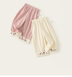 Dettaglio dei pantaloni in cotone per bambini con elastico e ricamo a fungo sul fondo