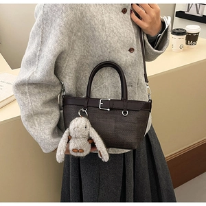 Détail du sac seau en cuir marron grainé avec charmant pendentif lapin en peluche