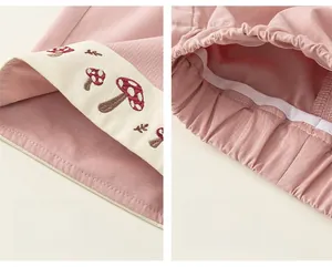 Dettagli dei pantaloni rosa per bambini con ricamo a fungo e cuciture in vita elastica