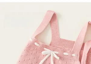Vista macro del morbido tessuto in maglia rosa e del fiocco decorativo sul gilet bimba