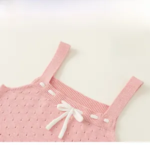 Dettaglio di canotta in maglia rosa per bambina con fiocco bianco e trama a costine fini