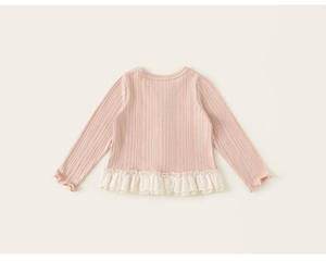 Detailed view of pink ribbed knit shirt for girls featuring lace trim and ruffled cuffs