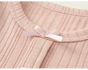 Close-up of pink ribbed knit top collar with a delicate sweet satin bow detail