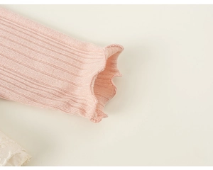 Detail of pink ribbed knit cuff with lettuce edge trim on girls long sleeve t-shirt