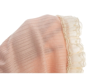 Detailed close-up of pink ribbed fabric sleeve with delicate floral lace embroidery