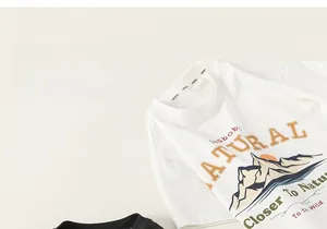 Detailed close-up of boy's cream cotton T-shirt featuring outdoor theme graphic print