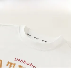 Detail of classic ribbed crew neck and premium cotton fabric on white boys' T-shirt
