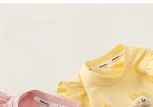 Close-up of cotton kids T-shirts with frill sleeves and 3D bow detail in pink and yellow