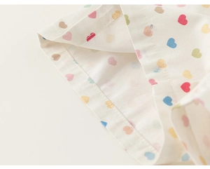 Détails de l'imprimé cœurs colorés et des finitions de couture sur le tissu en coton