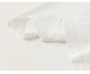 Close-up of high-quality double-needle stitching on the hem of a white cotton kids T-shirt