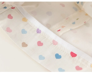 Détail du tissu à motif cœurs colorés avec double couture précise et passepoil blanc