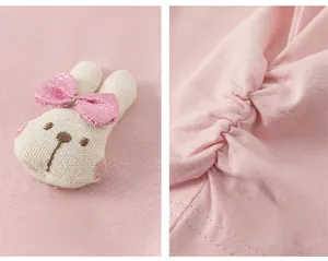 Detail of pink toddler top featuring a plush bunny ornament and side drawstring texture