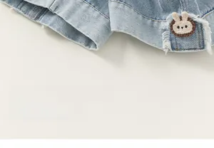 Détail d'un jean pour enfant avec broderie tête de lapin et revers de jambe élégants