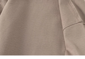 Detail of soft brown knit fabric with durable double-needle stitching on the side seam
