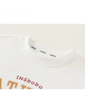 Close-up detail of white cotton T-shirt ribbed crew neck with INSbobo logo print