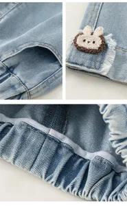 Détail d'un pantalon en jean bleu clair avec taille élastique et écusson lapin tricoté