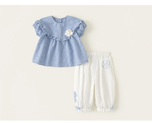 Detailed view of baby girl summer plaid top with flower decor and white lantern pants