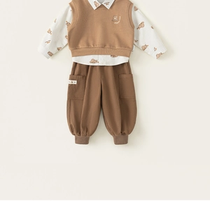 Detail of baby boy's three-piece set with bear pattern shirt, vest and casual pants