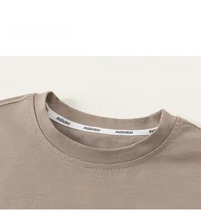 Detail of a brown cotton crew neck T-shirt with reinforced inner neck tape and neat stitching