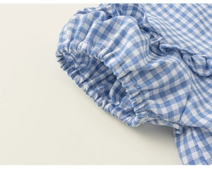 Detailed view of blue and white gingham cotton fabric with elastic ruffled cuffs
