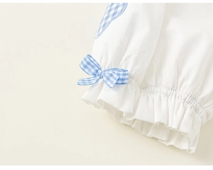 Detail of girls' cotton sleeve with blue plaid bow and ruffle edge design