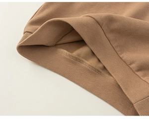 Close-up of brown knit sweater elastic ribbed hem showing premium stitching and texture