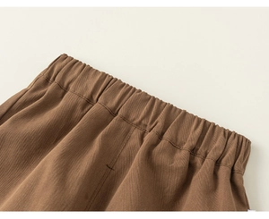 Detail of boys brown casual pants showing elastic waistband and neat double stitching