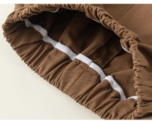 Detail shot of brown cotton trousers showing elastic waistband with high quality stitching