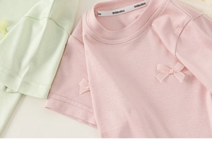 Nahaufnahme von Mädchen T-Shirts mit Seidenschleifen und weicher Strickstruktur