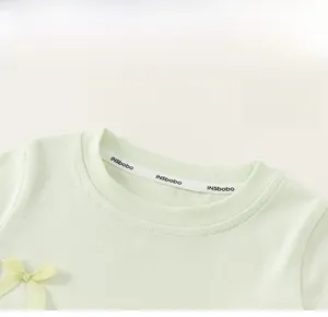 Nahaufnahme eines minzgrünen Kinder-Strick-T-Shirts mit Rundhalsausschnitt und Schleife