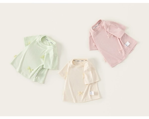 Flachliegende Detailansicht weicher Kinder-T-Shirts in Pastellgrün, Creme und Rosa